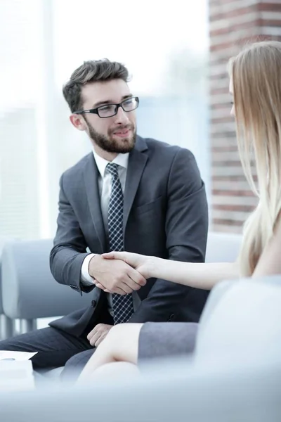 Primer plano de un gerente le da la mano a un cliente regular . — Foto de Stock