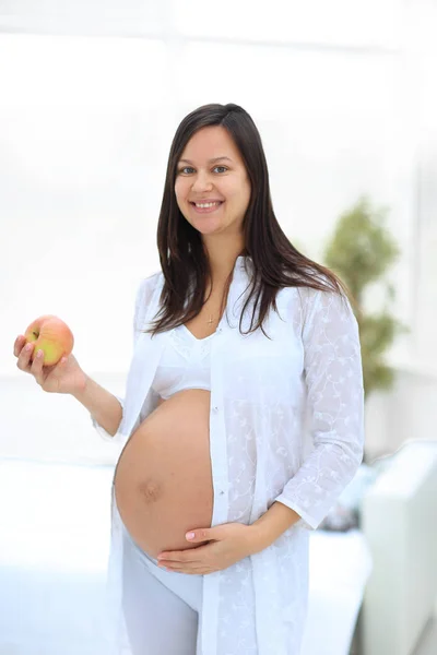 Leende gravid kvinna med ett äpple — Stockfoto