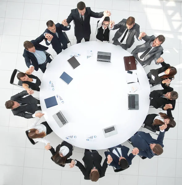 Grande équipe d'affaires assis à la table ronde et lever les mains vers le haut — Photo