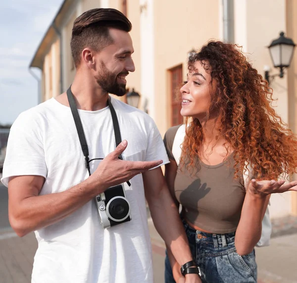 Casal de turistas olham um para o outro e andando — Fotografia de Stock