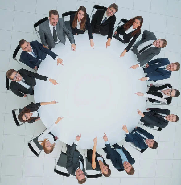 Vista superior del equipo de negocios smilimg, sentado en una mesa redonda en w — Foto de Stock