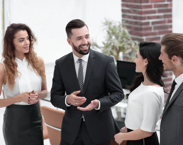 Sonriente equipo de negocios hablando, de pie en la oficina — Foto de Stock