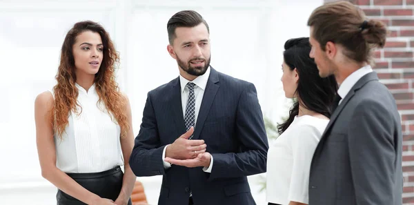 Sonriente equipo de negocios hablando, de pie en la oficina — Foto de Stock