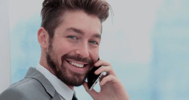 Yakışıklı iş adamı smartphone kullanarak bir ofiste