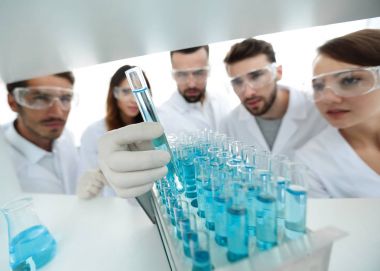 arka plan görüntüsü sıvı cam tüp içinde eğitim microbiologists oluşan bir gruptur.