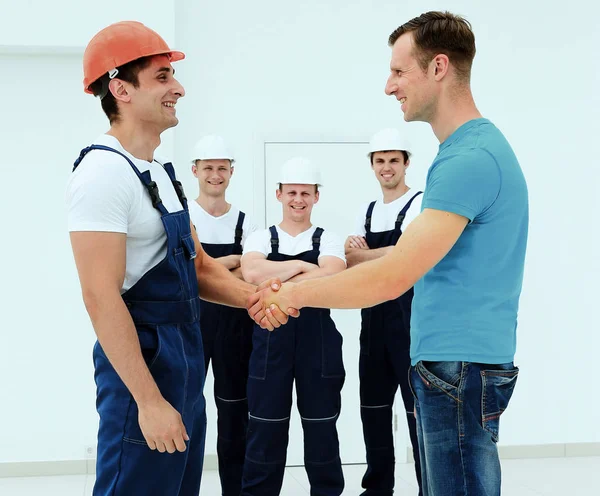 Клієнт тремтить руками з будівельником — стокове фото