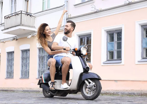 Full length side view of happy couple riding on retro motorbike — Stock Photo, Image