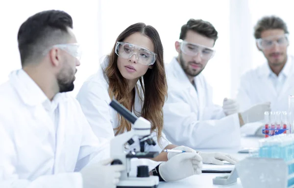 Jóvenes científicos discutiendo los resultados de los experimentos en el laboratorio — Foto de Stock