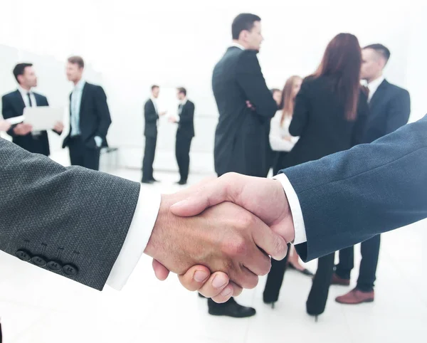 Two businessmen making agreement, their colleagues standing near Royalty Free Stock Images