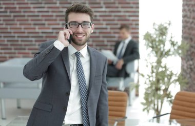 ofisinde smartphone cep telefonu ile konuşurken işadamı