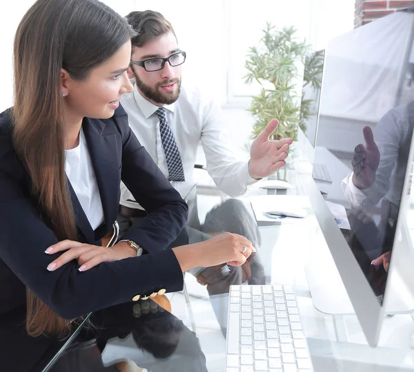 Affärskvinna med en kollega som sitter vid ett skrivbord — Stockfoto