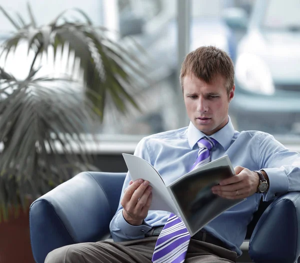 Бизнесмен читает журнал в приемной — стоковое фото