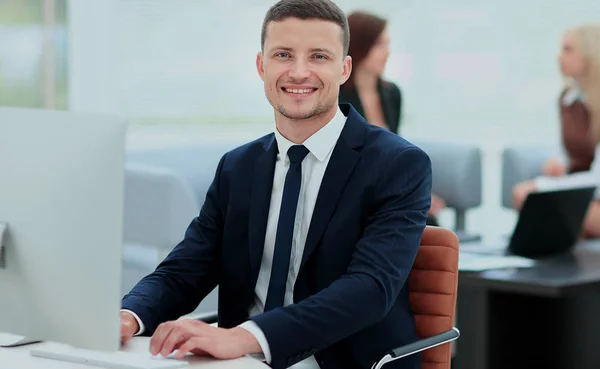 Sorridente uomo d'affari in piedi con i suoi collegi in background a — Foto Stock