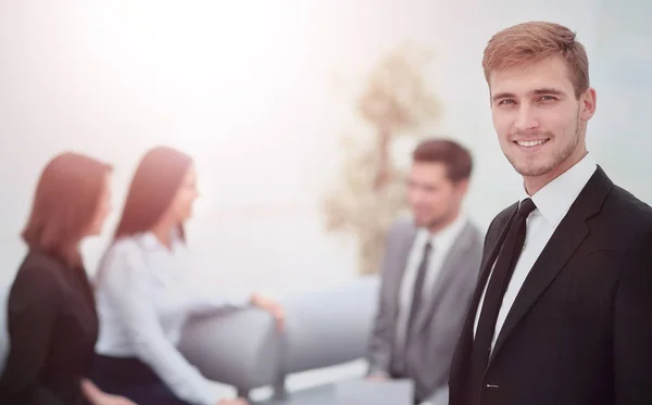 Erfolgreicher Geschäftsmann, der mit seinen Mitarbeitern im Hintergrund bei — Stockfoto