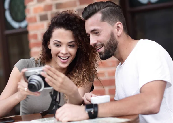 Retrato de um casal sentado em um café e olhando fotos — Fotografia de Stock