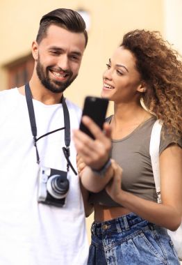 Mutlu genç çift cep telefonuyla yer arıyor.