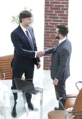 İki işadamı ofiste el sıkışıyor.