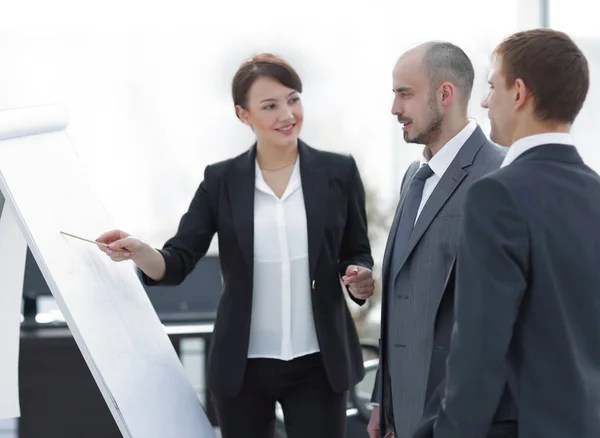 Geschäftsfrau zeigt einem Geschäftsteam Informationen auf dem Flipchart — Stockfoto