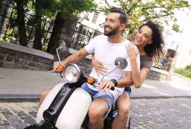 Şık genç çift bir scooter sokakta oturuyor..