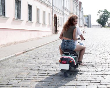 mutlu genç bir çift bir scooter üzerinde eğleniyor