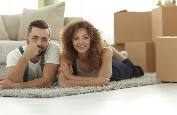Happy couple lies on the floor in a new apartment