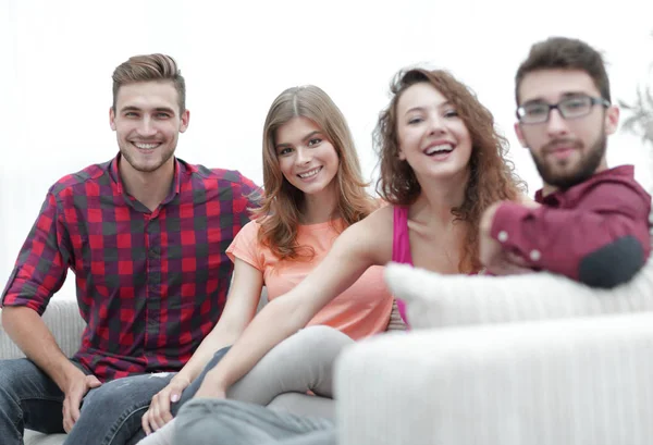 Группа веселых друзей, сидящих на диване — стоковое фото