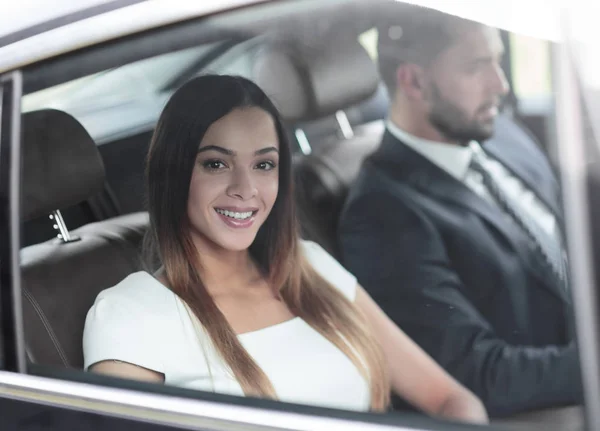 Porträt einer Frau im weißen Kleid in ihrem Auto auf dem Rücksitz — Stockfoto