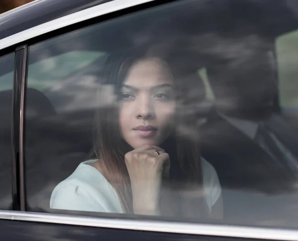 Mujer de negocios pensativo sentado en el asiento trasero del coche — Foto de Stock