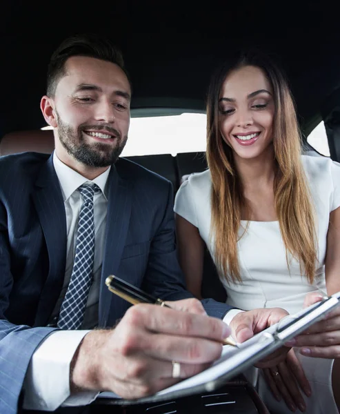 Mooie zakenvrouw werkt met een client in de auto — Stockfoto