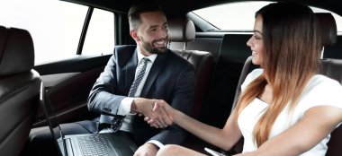 Karşılıklı iş adamları bir arabanın arka koltuğunda