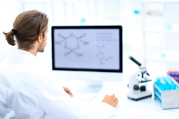 Young man working in a medical lab using a computer — Stock Photo, Image