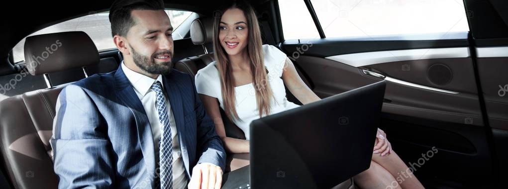 Business man and woman working together in the car