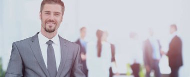 ofisinde memnuniyeti ile kameraya bakarak mutlu olgun iş adamı