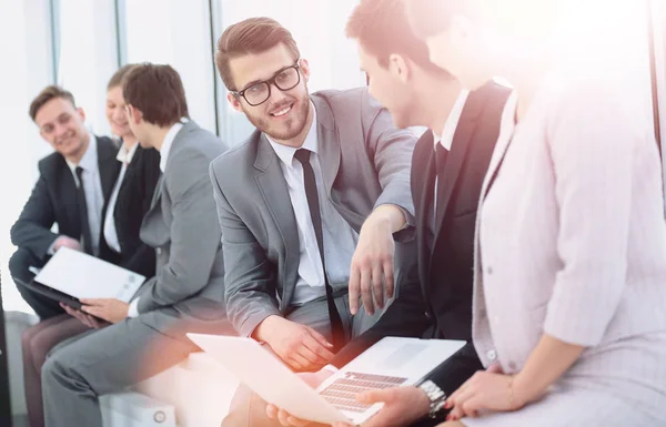 Equipo de negocios con ordenador portátil y papeles sentarse y hablar en el vestíbulo b — Foto de Stock