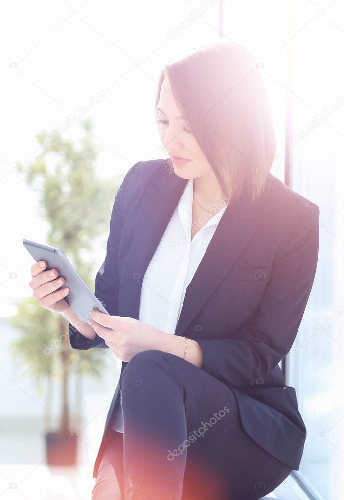 happy young woman using digital tablet in office