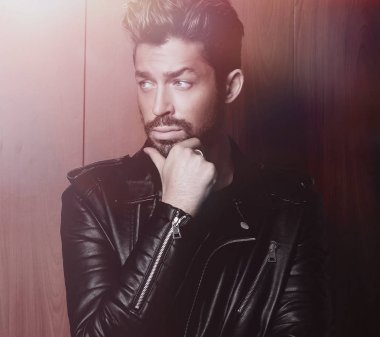 Ahşap duvara yaslanmış yakışıklı bir adamın portresi..