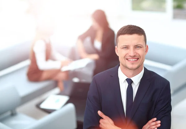 Sonriente hombre de negocios de pie con sus colegios en el fondo un — Foto de Stock