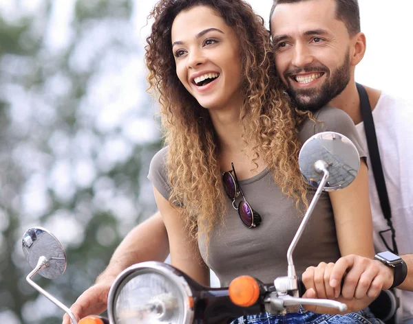 Atractiva pareja montando un scooter en un día soleado en la ciudad —  Fotos de Stock