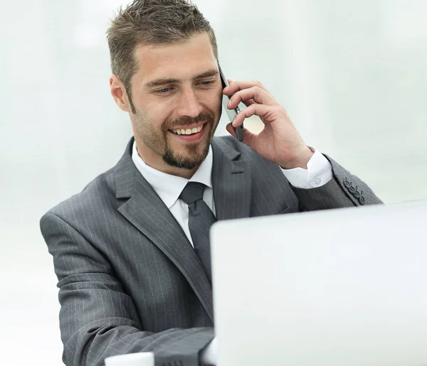 Closeup.successful empresário trabalhando no laptop e falando no telefone . — Fotografia de Stock