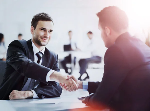 Zwei Geschäftskollegen beim Händeschütteln während eines Meetings — Stockfoto