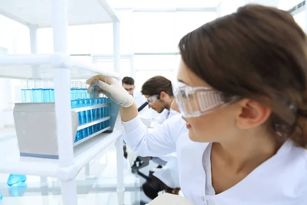 Giovane donna con provette in laboratorio — Foto Stock