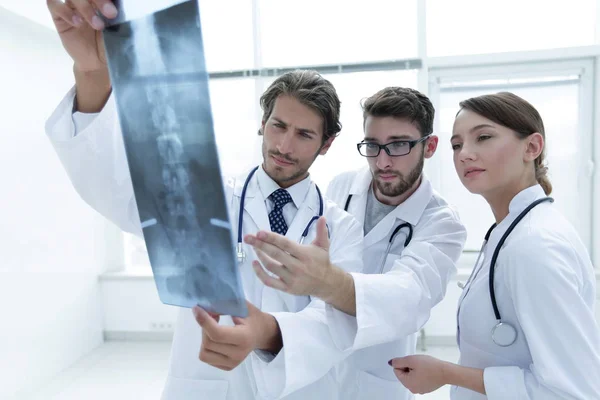 Trois médecins confiants examinent une radiographie — Photo
