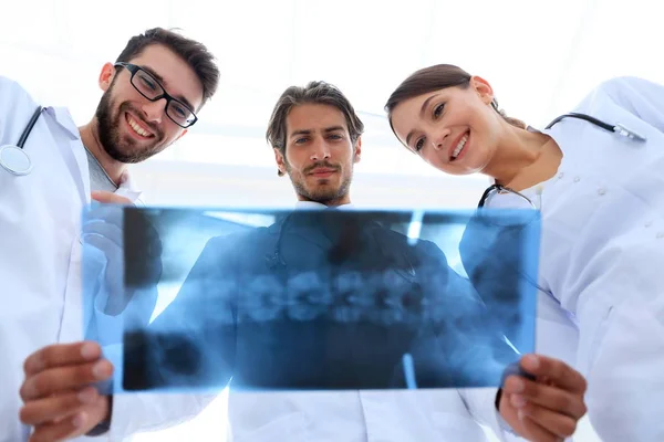 Три лікарі вивчають рентгенівську плівку — стокове фото