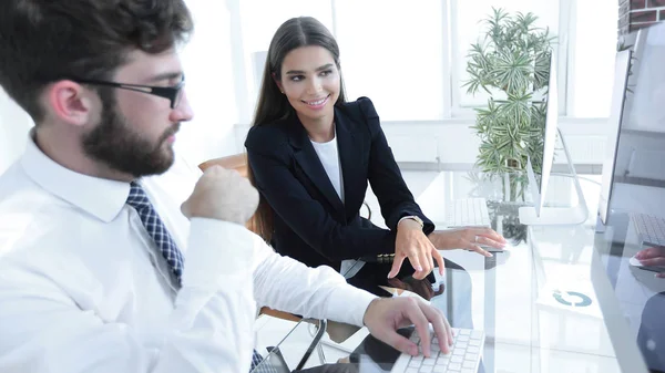 Hombre de negocios y su asistente femenino sentado en un escritorio — Foto de Stock