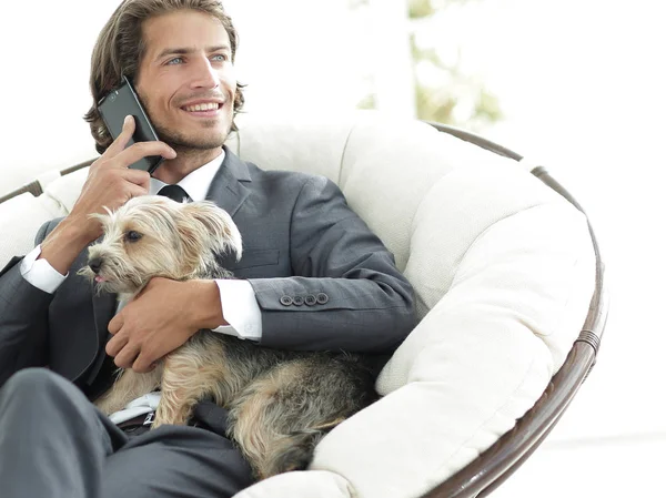 Exitoso empresario sostiene a su perro y mascota y habla en el teléfono inteligente —  Fotos de Stock