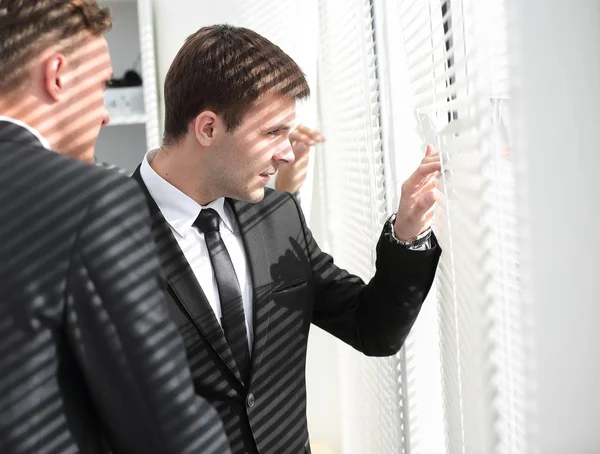 Üzletemberek néz ki az ablak irodában — Stock Fotó