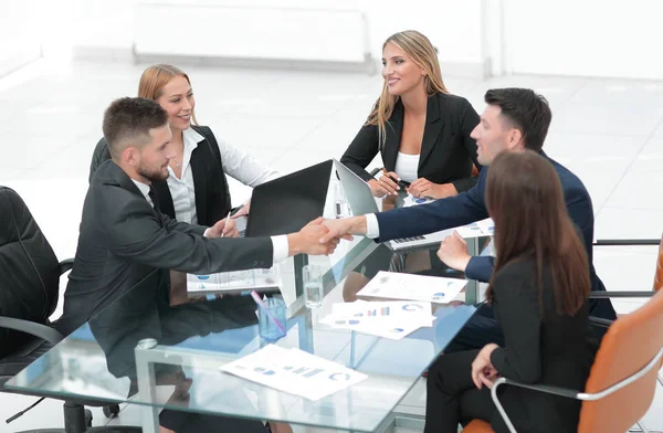 Handshake obchodních partnerů sedí u stolu — Stock fotografie