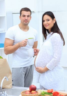 karı ve onun hamile eşi kakao içmeye, mutfakta ayakta.