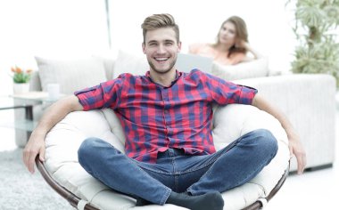 arka plan bulanık bir büyük yuvarlak sandalyede oturan modern genç adam