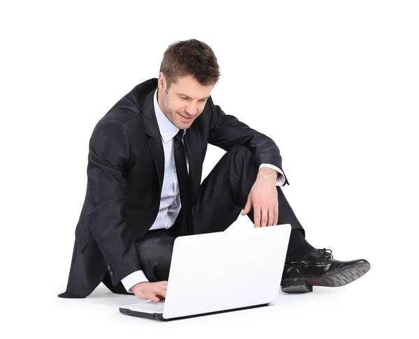 一个拿着笔记本电脑坐在地板上的商人. — 图库照片